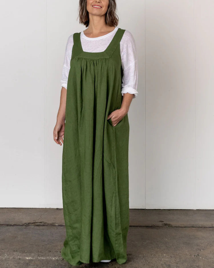 Woman wearing a green dress over a white shirt against a plain background